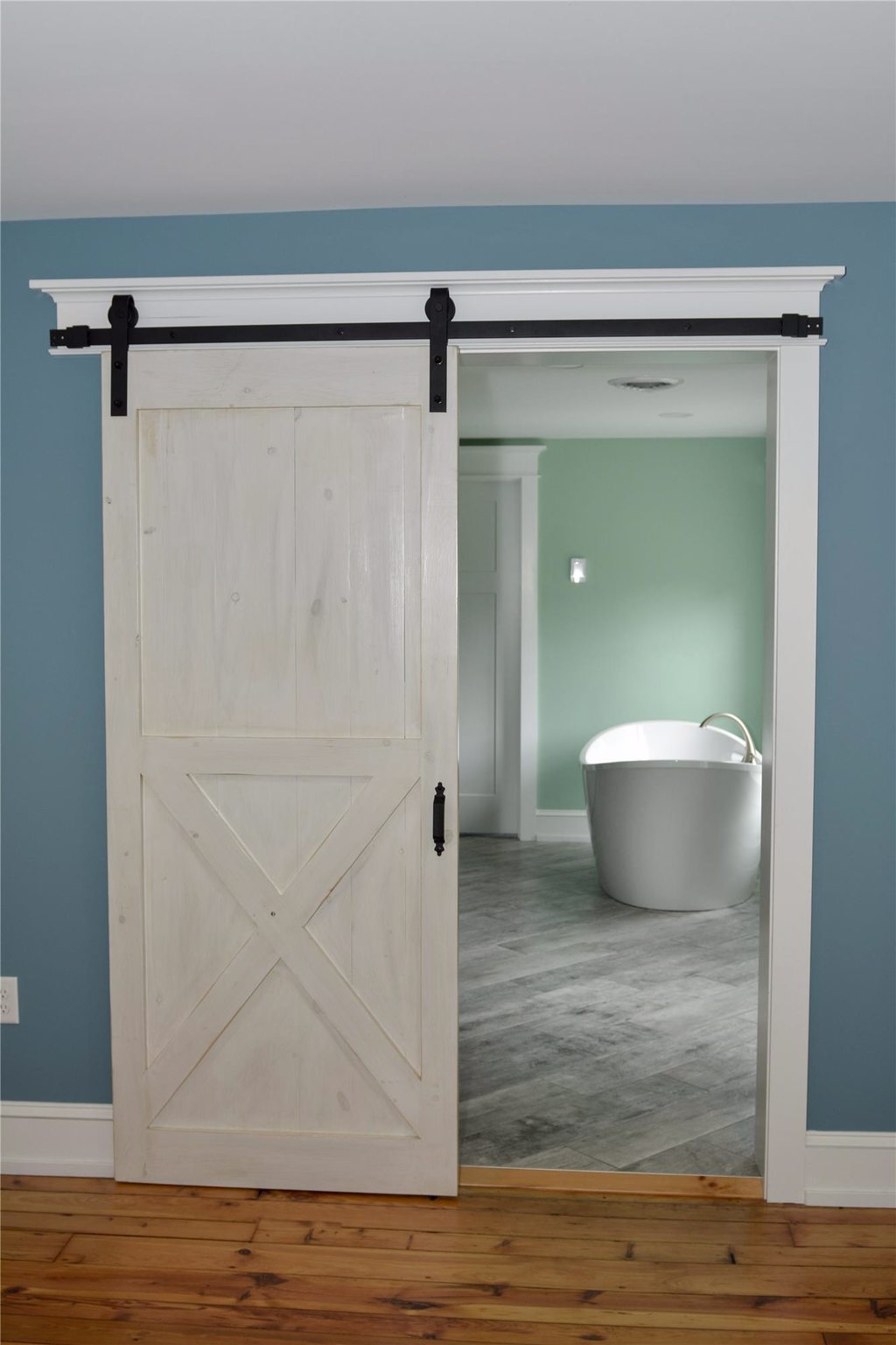 Master Bathroom Behind Sliding Barn Door with Crown Molding